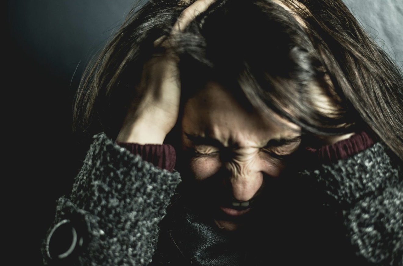 Angry woman holding her head.